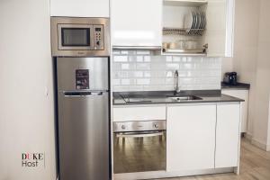 uma cozinha com um frigorífico de aço inoxidável e um micro-ondas em Santa Maria de la cabeza Apartments em Madri