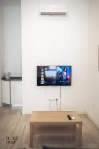 uma televisão de ecrã plano pendurada numa parede branca em Santa Maria de la cabeza Apartments em Madri