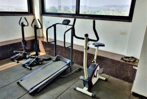 a group of cardio machines in a gym with windows at Click Hotel Sagar Plaza Chakan, Pune in Chakan