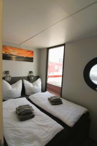 two beds in a hotel room with towels on them at Hausboot Fjord Nordstern mit Dachterrasse in Schleswig in Schleswig