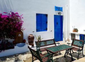 un patio con mesa, sillas y puertas azules en Irene's house, en Lachania