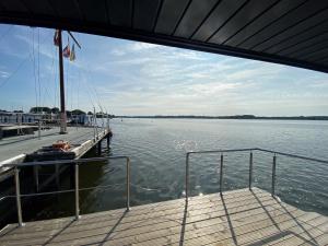 a boat is docked at a dock on the water at Hausboot Fjord Nordstern mit Dachterrasse in Schleswig in Schleswig
