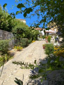 un camino en un jardín con flores y plantas en Sa domu de don Ninnu bed breakfast Spa en Gesturi