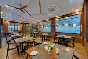 a restaurant with wooden tables and chairs and a large window at Click Hotel Sagar Plaza Chakan, Pune in Chakan