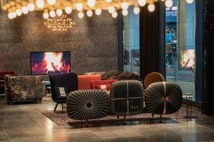 eine Lobby mit Stühlen und einem TV in einem Gebäude in der Unterkunft Motel One Berlin-Alexanderplatz in Berlin