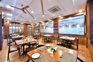 a restaurant with wooden tables and chairs and a ceiling at Click Hotel Sagar Plaza Chakan, Pune in Chakan