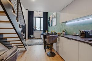 a kitchen with a counter and a staircase in a room at Tempus Te Premium Duo Lofts Tartu - private cinema, gym and terrace in Tartu