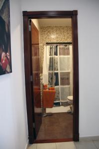 Un baño con una puerta de cristal que conduce a un inodoro. en Tonono´s Village, en Santa María de Guía de Gran Canaria