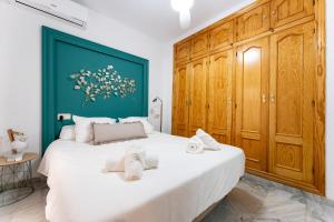 - une chambre avec un grand lit blanc et des placards en bois dans l'établissement Vive Fuengirola, à Fuengirola