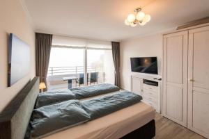 a bedroom with a large bed and a television at Förde-Lodge in Glücksburg