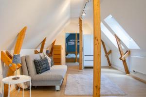 een woonkamer met een stoel en een trap bij Atelierhaus Glücksburg Sandwig in Glücksburg