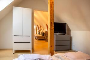 een slaapkamer met een witte dressoir en een tv bij Atelierhaus Glücksburg Sandwig in Glücksburg