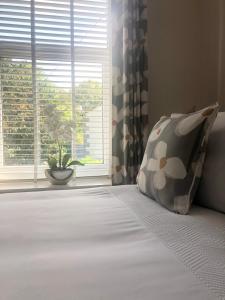 a bedroom with a bed with a pillow and a window at Riverside Cottage in Whalley
