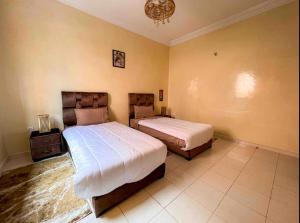 1 Schlafzimmer mit 2 Betten und einem Kronleuchter in der Unterkunft Marrakech Mirage Home in Marrakesch