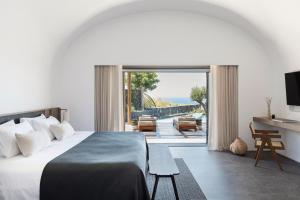 伊亚Canaves Epitome - Small Luxury Hotels of the World的一间带床的卧室，可欣赏庭院景观