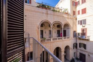 - une vue extérieure sur un bâtiment avec des arches et un escalier dans l'établissement Little House Mavi by DomuSicily, à Palerme