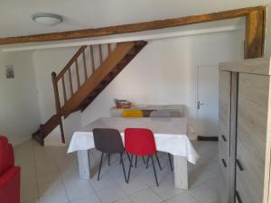 a dining room table with two chairs and a staircase at Gîte Linglet in Fumay