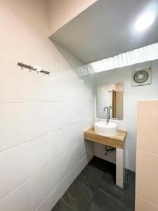 La salle de bains est pourvue d'un lavabo et d'un miroir. dans l'établissement Srikij GardenHome Resort, à Sa Kaeo