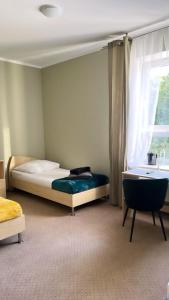 1 dormitorio con cama, ventana y lavamanos en Villa Ventana 2 City Free Parking Śniadanie w cenie 503 18 18 11, en Poznan