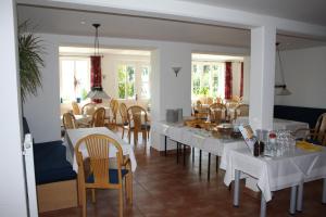 a dining room with white tables and chairs at Hotel Garni Meeresgruß in Sassnitz
