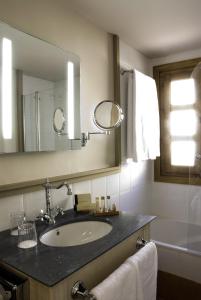 
a bathroom with two sinks and a mirror at Hotel San Antonio el Real in Segovia
