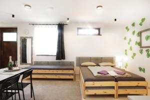 1 dormitorio con 2 camas, mesa y sillas en Apartmán Wellness Veselí en Veselí nad Moravou