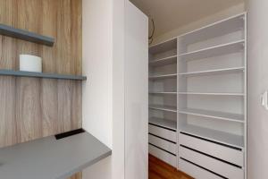 a walk in closet with white walls and wooden shelves at The presidential studio in Bratislava