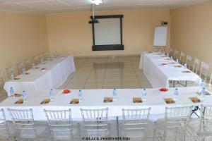 rzędu stołów w pokoju z białą pościelą w obiekcie Meet Mekaar Resorts - Nquthu Hotel w mieście Nqutu