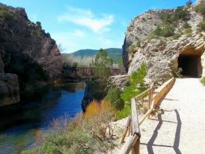 un pont sur une rivière avec un chemin à proximité dans l'établissement ALBERGUE CONTRERAS, à Minglanilla