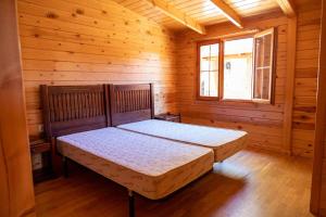 um quarto com uma cama num chalé de madeira em ALBERGUE CONTRERAS em Minglanilla