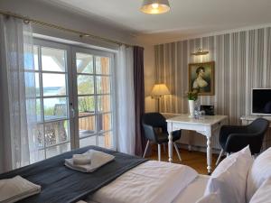 ein Hotelzimmer mit einem Bett, einem Schreibtisch und einem Fenster in der Unterkunft Seehotel Lichtenberg in Lichtenberg