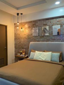 una camera con un letto con un muro di mattoni di Lovely Unit with free wi-fi & netflix I across Naia T3 airport a Manila