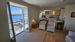 a kitchen and living room with a view of the water at Pennant in Saint Mawes