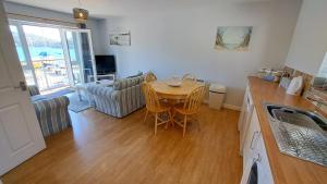 a kitchen and living room with a table and chairs at Polmaro in Saint Mawes +14 photos
