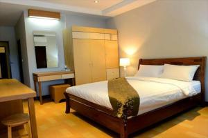 1 dormitorio con cama, mesa y espejo en My Living Place Samui, en Mae Nam