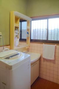 La salle de bains est pourvue d'un lave-linge et d'un lavabo. dans l'établissement 四万十川傍にある日本家屋まるごと「貸切宿　ほとり」, à Shimanto