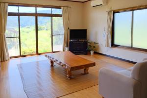 sala de estar con mesa de centro y sofá en 四万十川傍にある日本家屋まるごと「貸切宿　ほとり」, en Shimanto
