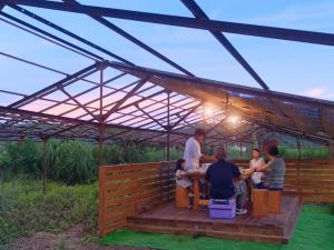 een groep mensen aan een tafel onder een luifel bij 四万十川傍にある日本家屋まるごと「貸切宿　ほとり」 in Shimanto