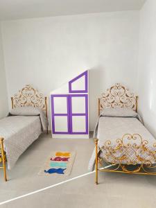 1 dormitorio con 2 camas y alfombra en el suelo en Pierina's house - Vista colline, en Bonnanaro