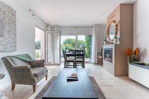 ein Wohnzimmer mit Tisch und Stühlen in der Unterkunft Casa Gosia bungalow Cabopino in Marbella