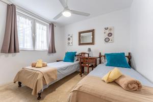 ein Schlafzimmer mit zwei Betten und einem Tisch und einem Spiegel in der Unterkunft Casa Gosia bungalow Cabopino in Marbella + 21 Fotos
