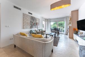 ein Wohnzimmer mit Couch und ein Esszimmer in der Unterkunft Casa Gosia bungalow Cabopino in Marbella