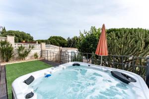 einen Whirlpool im Garten mit Sonnenschirm in der Unterkunft Casa Gosia bungalow Cabopino in Marbella