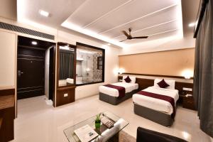 a hotel room with two beds and a couch at Click Hotel Sagar Plaza Chakan, Pune in Chakan