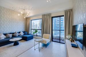 - un salon avec un canapé bleu et une table dans l'établissement Bahar Residence, JBR, Dubai Marina, à Dubaï