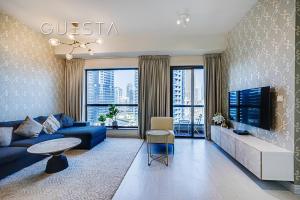 een woonkamer met een blauwe bank en een tv bij Bahar Residence, JBR, Dubai Marina in Dubai