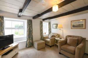 a living room with two chairs and a television at April Cottage in Saint Just in Roseland