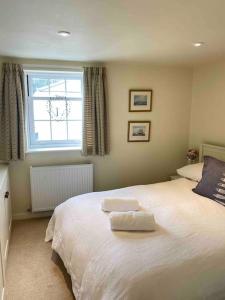 a bedroom with a bed with two towels on it at High end cottage in amazing location. Only 1 minute from the sea! Beautifully decorated 3 level home. 5* reviews in Lyme Regis