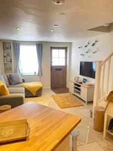 a living room with a couch and a tv at High end cottage in amazing location. Only 1 minute from the sea! Beautifully decorated 3 level home. 5* reviews in Lyme Regis
