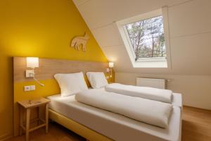 two beds in a room with yellow walls and a window at Center Parcs Eifel Mosel Nürburgring in Gunderath +157 photos